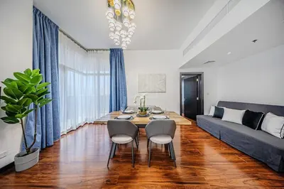 a living room with a couch and a table and chairs at Amazing 1BR apartment near metro station in JLT in Dubai