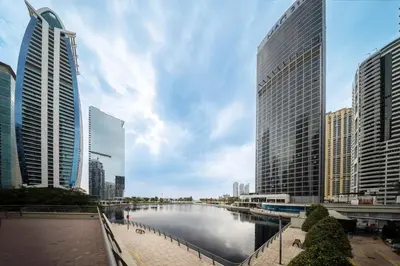 a river in a city with tall buildings at Amazing 1BR apartment near metro station in JLT in Dubai