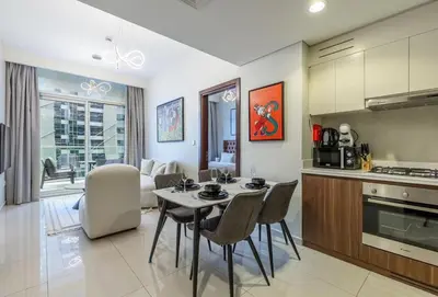 a kitchen and living room with a table and chairs at stylish 2 bedroom Apt in Business bay Dubai in Dubai