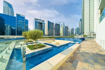 a pool in the middle of a city with tall buildings at stylish 2 bedroom Apt in Business bay Dubai in Dubai
