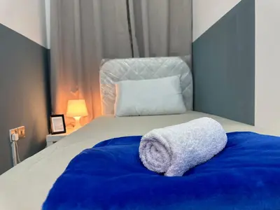 a bed with a towel on top of it at Partition Room with window In Barsha Near Metro in Dubai
