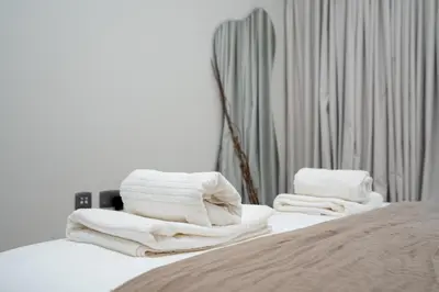 a pile of towels sitting on top of a bed at Modern 1-Bedroom Retreat in MBR City in Dubai