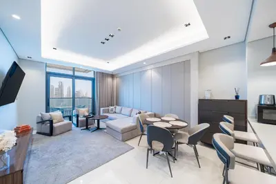 a living room with a couch and a table and chairs at Luxe 3BDR Panoramic Burj Khalifa Views Business Bay in Dubai
