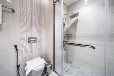 a white bathroom with a shower and a toilet at Luxe 3BDR Panoramic Burj Khalifa Views Business Bay in Dubai