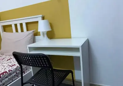 a white desk with a chair next to a bed at City Stay Partition Room in al Barsha 1 Near Metro in Dubai
