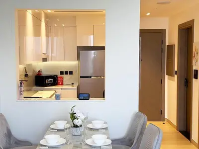 a dining room with a table and chairs and a kitchen at Luxurious new 1 bedroom with Balcony and New Building in Dubai
