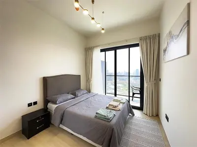 a bedroom with a bed and a large window at Luxurious new 1 bedroom with Balcony and New Building in Dubai