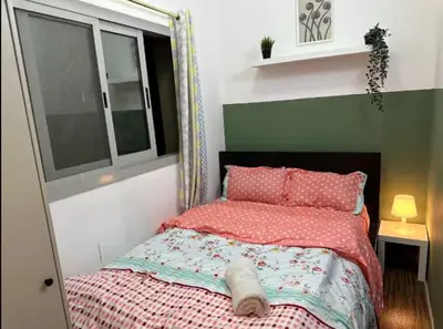a bedroom with a bed with pink sheets and a window at Double Bed Partition Room Near Mashreq Metro in Dubai