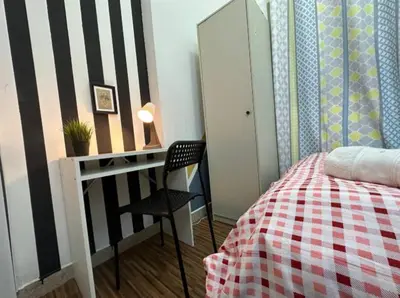 a bedroom with a bed and a desk and a chair at Double Bed Partition Room Near Mashreq Metro in Dubai
