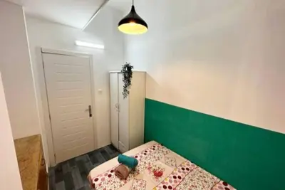 a room with a bed with a green and white wall at Bagpack Double Partition Room in Tecom Near Metro in Dubai