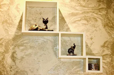 two statues of cats sitting on shelves on a wall at Luxuriously Designed Spacious Studio In JVC in Dubai
