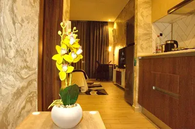 a vase with yellow flowers on a table in a kitchen at Luxuriously Designed Spacious Studio In JVC in Dubai