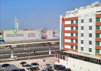 a parking lot with cars on a highway next to a building at Loft Room in Al Barsha 1 Near MOE Metro in Dubai