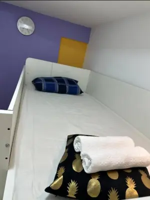 a white bed with a pillow and a towel on it at Loft Room in Al Barsha 1 Near MOE Metro in Dubai
