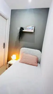 a bedroom with a bed with a pink pillow at Compact Partition Room in Barsha in Dubai