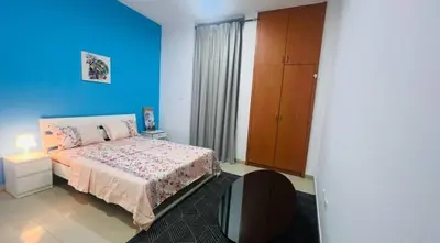 a bedroom with a bed and a blue wall at Newly Furnished Room in Barsha 1 Near MOE in Dubai