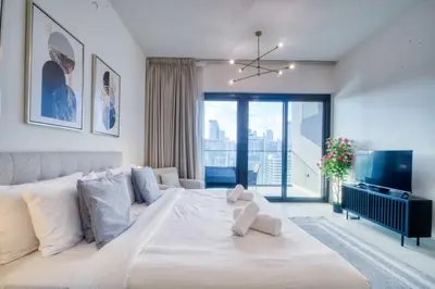 a bedroom with a large white bed and a large window at AWS Holiday Homes - Dreamful Views of the Burj in Dubai
