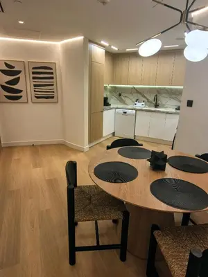 a dining room with a table and a kitchen at 85m2 En Suite, DIFC in Dubai
