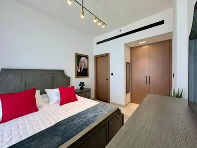 a bedroom with a large bed with red pillows at Chic & Modern 1br In Jvc With Full Amenities in Dubai