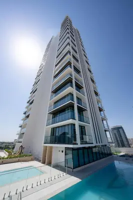 a tall building with a pool in front of it at Chic & Modern 1br In Jvc With Full Amenities in Dubai
