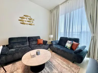 a living room with a couch and a table at Chic & Modern 1br In Jvc With Full Amenities in Dubai