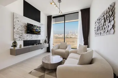 a living room with two chairs and a table at Daniels Stylish 1BR Apartment with Al khail View in Dubai