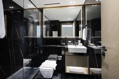 a bathroom with a toilet and a sink and a mirror at Daniels Stylish 1BR Apartment with Al khail View in Dubai