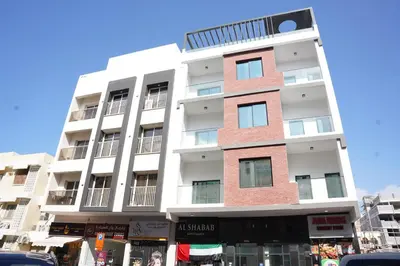 a tall white building on a city street at Ista Vacation Homes Rental LLC KARAMA in Dubai