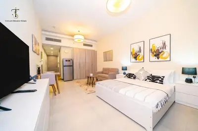 a white bedroom with a large bed and a living room at Splendid City Views Studio- SOL BAY Business Bay in Dubai