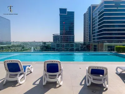 two chairs and a swimming pool with a city at Splendid City Views Studio- SOL BAY Business Bay in Dubai