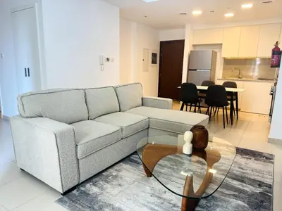 a living room with a couch and a table at 02 Bedroom Apartment in Townsquare in Dubai