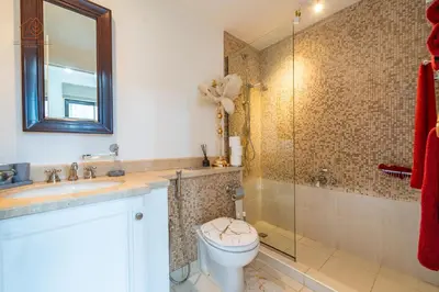 a bathroom with a toilet and a glass shower at Cozy Old Town 2-Bed Apartment with Burj Khalifa Views 202RH-2 in Dubai