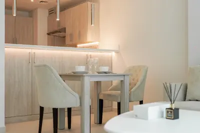 a kitchen with a table and chairs in a room at 1BR Palm Jumeirah - Rooftop Pool & Beach Access in Dubai