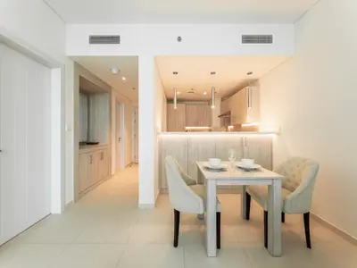a kitchen and dining room with a table and chairs at 1BR Palm Jumeirah - Rooftop Pool & Beach Access in Dubai