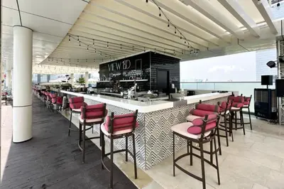 a restaurant with a bar with red chairs at 1BR Palm Jumeirah - Rooftop Pool & Beach Access in Dubai