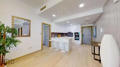 a kitchen with white walls and a wooden floor at Spacious 3BR Apartment in Dubai