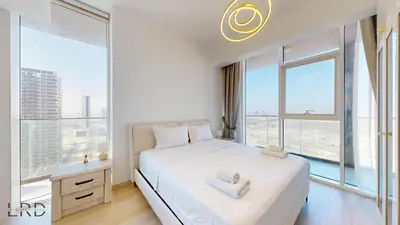 a bedroom with a white bed with a large window at Spacious 3BR Apartment in Dubai