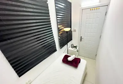 a bathroom with a white bench and a window at Partitioned Single Room in Al Barsha 1 Near Metro in Dubai