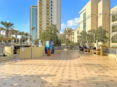 a walkway in a city with tall buildings at Cozy Studio with Scenic Canal Views in Dubai