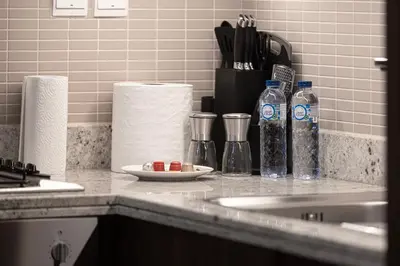 a kitchen counter with bottles of water and medicines at Luxe 1BR with Full Burj Views and Dubai Mall Access in Dubai