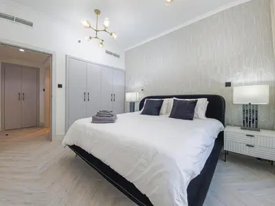 a bedroom with a large bed and a chandelier at Luxury 2-bed Condo Full Burj Khalifa Lights View! in Dubai