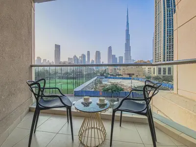 a balcony with a table and chairs and a view of a city at Luxury 2-bed Condo Full Burj Khalifa Lights View! in Dubai