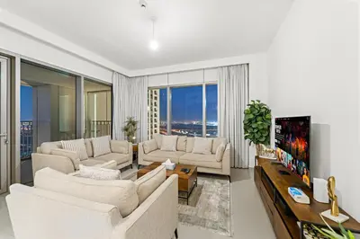 a living room with two white couches and a tv at Elegant 2BR in Downtown Dubai l Walk to Dubai Mall in Dubai