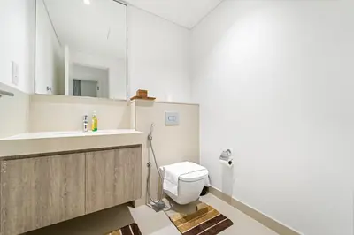 a bathroom with a white toilet and a sink at Elegant 2BR in Downtown Dubai l Walk to Dubai Mall in Dubai