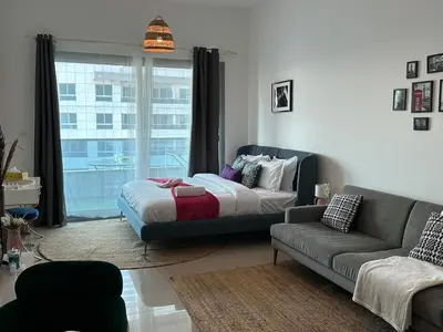a living room with a bed and a couch at Cozy Studio- Dubai Marina in Dubai