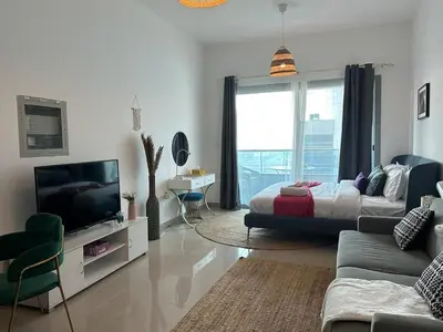 a living room with a bed and a television at Cozy Studio- Dubai Marina in Dubai