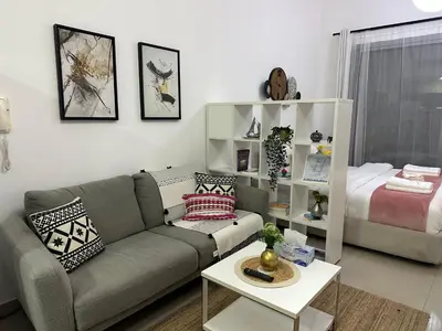 a living room with a couch and a bed at Studio Apartment- Dubai Marina in Dubai