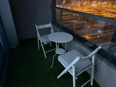 a table and two chairs on a balcony at night at Studio Apartment- Dubai Marina in Dubai