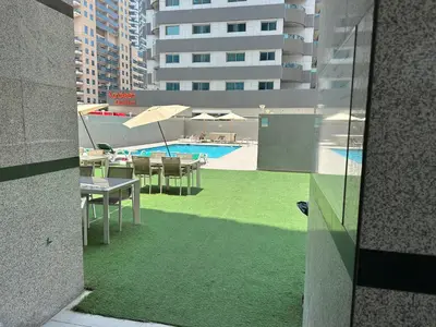 a view of a swimming pool with tables and chairs at Studio Apartment- Dubai Marina in Dubai