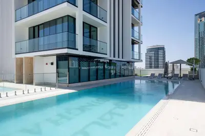 a swimming pool in front of a building at Modern & Elegant 1br Apartment In Jvc in Dubai
